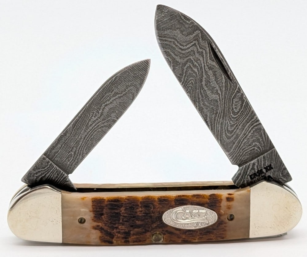 1989 Case XX Rogers Bone Damascus Canoe Knife ROG62131: Knife is in nice condition with some scuffs and tarnishing on the bolsters from handling. Overall measures 3-5/8in when closed.