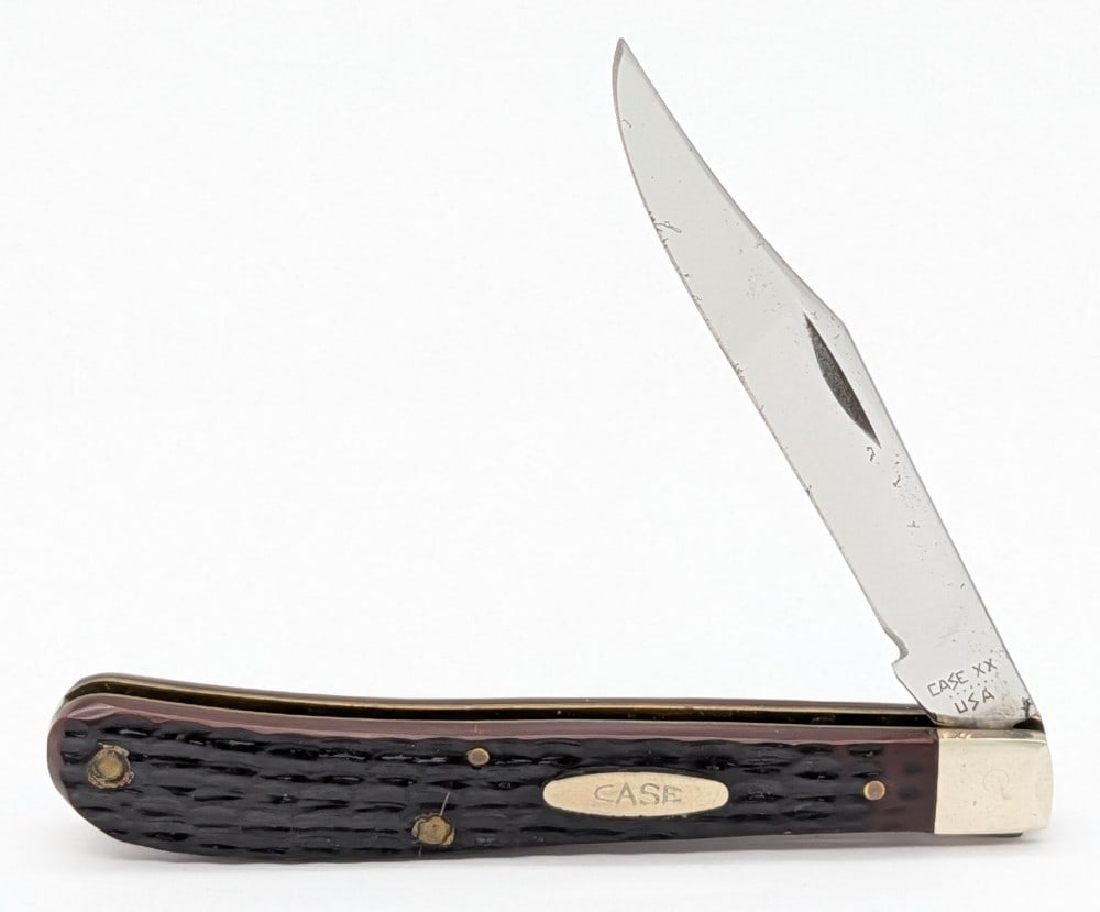1984 Case XX Delrin New Grind Slimline Trapper 61048: Knife is in fair condition with light carbon spots on the blade, light scuffs on the bolsters, and a pin crack on the front handle scale. Overall measures 4-1/8in when closed.