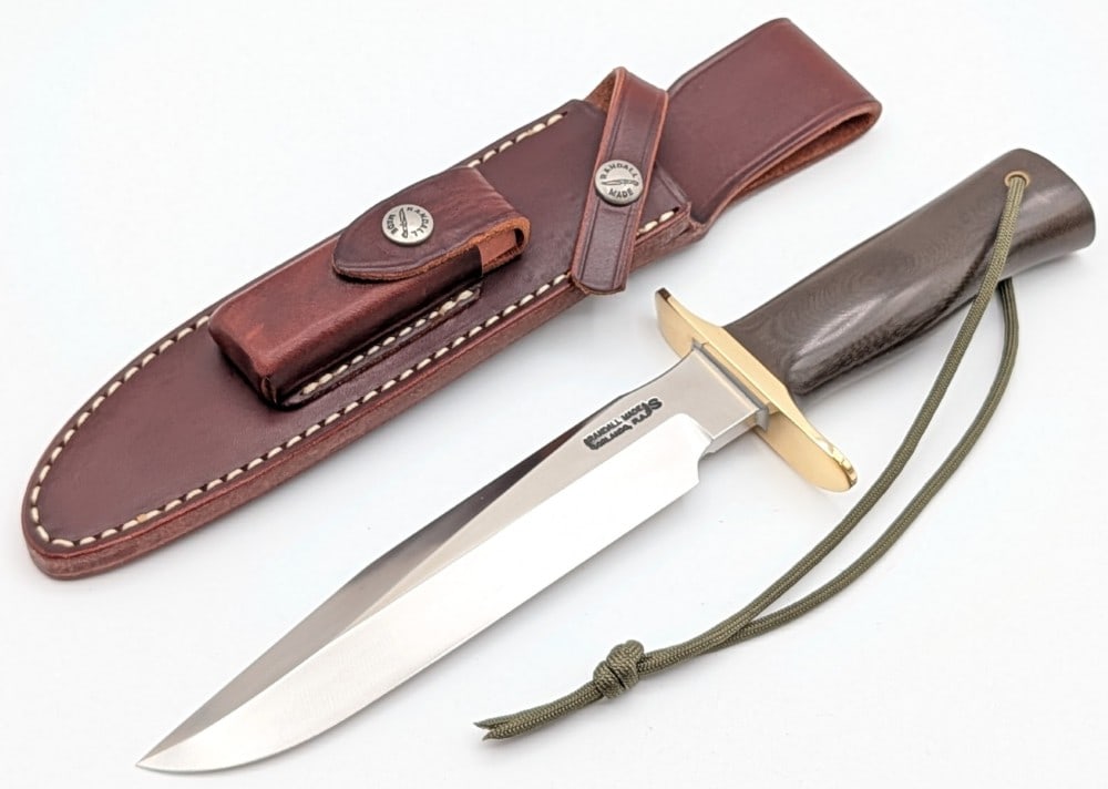 Randall Model 1 7in Full Tang All Purpose Fighter w/ Sheath: Features a stainless steel blade, a brass double downturned guard, full tang handle construction, and a brown micarta border patrol handle with a lanyard hole. Knife is in like new condition. Blade le