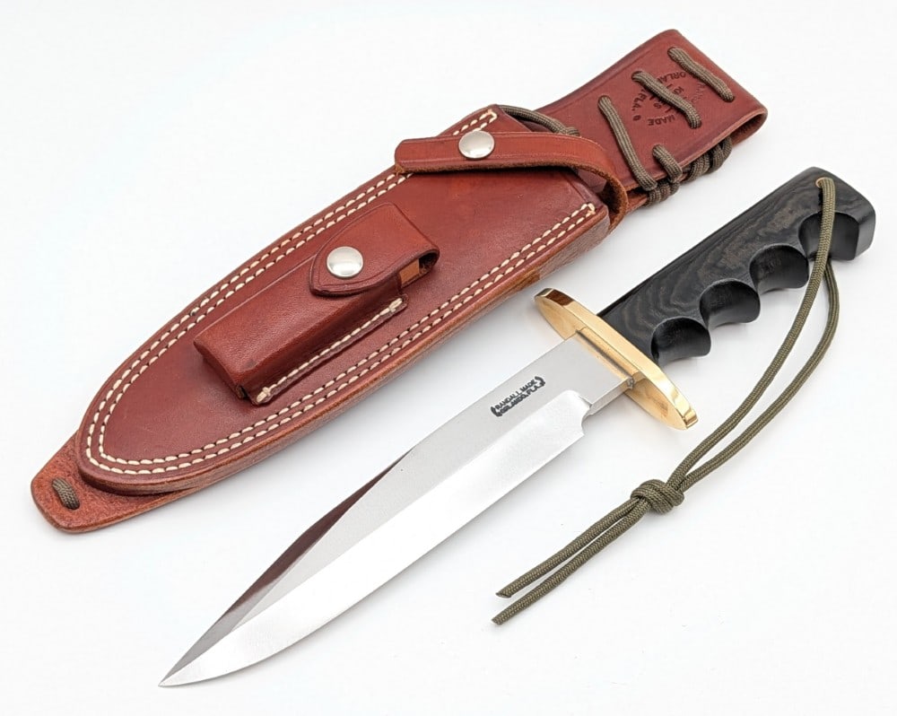 Randall Model 14 Attack w/ Sheath: Features a brass double oblong guard, a full tang handle construction, and a black micarta finger groove handle with a lanyard hole. Knife is in very nice condition with a few light scratches on the b