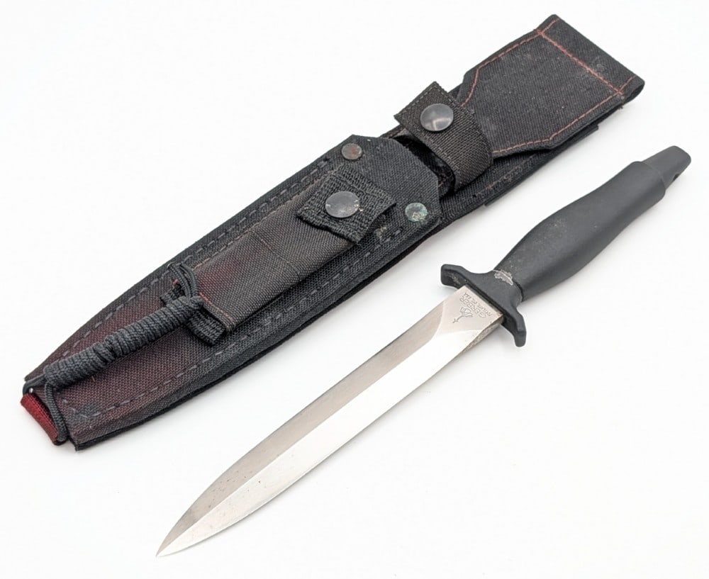 1985 Gerber Mark II Fighting Knife w/ Sheath: Features a straight double edged blade, and an integral guard and handle coated in a fused armorhide coating. Knife is in good condition with a few small spots of rust on the blade, and some dings and