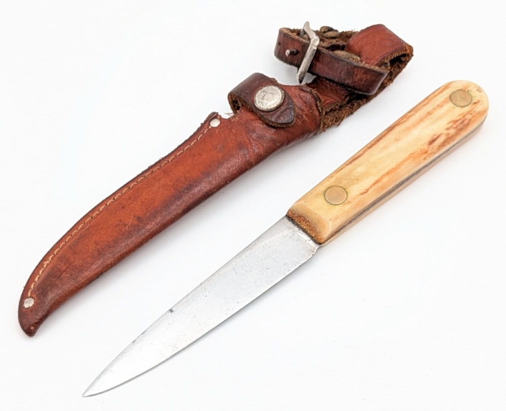 Early Lile Shop Pinned Stag Utility Knife w/ Sheath: Features the phrase Made In Lile Shop in cursive on the blade, and stag handle scales with iconic large brass pins. Comes in a unique tube leather sheath. Knife is in well used condition with scratche