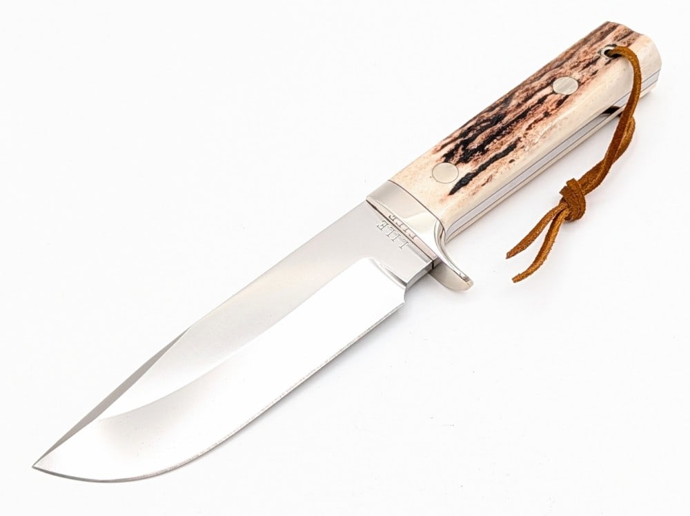 Heavy Lile Stag Chopper Fixed Blade Knife: Features a large 5mm thick bowie blade, a nickel silver downturned guard, full tang handle construction, and stag handle scales with contoured nickel silver pins with a lanyard hole. Knife is in like 