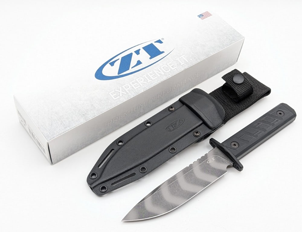 NIB Zero Tolerance ZT Model 0006 Tiger Stripe Fixed Blade Knife w/ Sheath: Features a tiger stripe finish drop point blade with thumb notches, a powder coated black finish steel guard and butt cap, full tang handle construction, and black G-10 handle scales. Knife is in new 