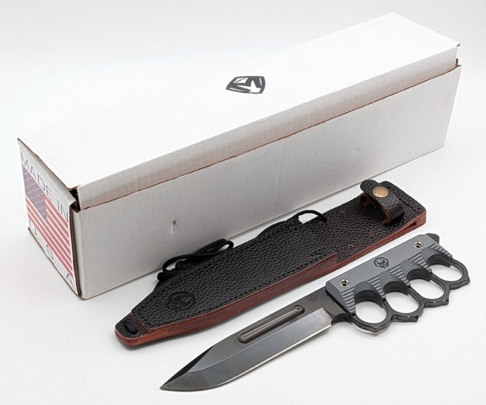 NIB Medford Knife & Tool US 2024 1881 Knuckle Knife w/ Sheath: Features a black oxide finish drop point fullered blade, full tang handle with knuckles and skull crusher pommel, and black gray layered G-10 handle scales. Comes in the box with all the ephemera and 