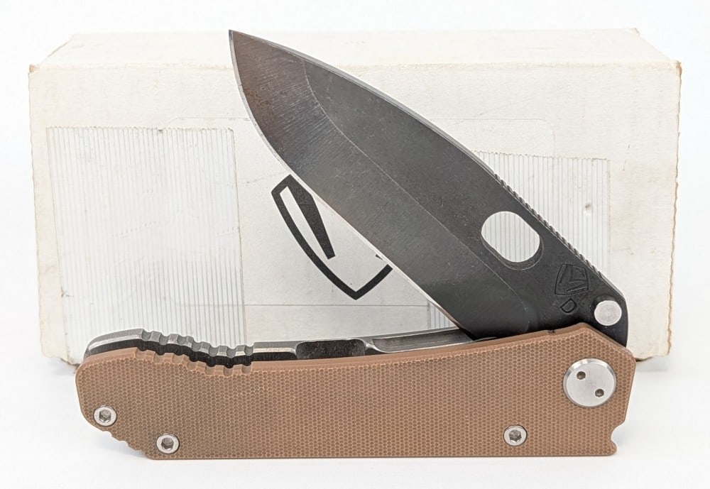 Medford Knife & Tool Model 187 Folding Knife w/ Box: Features a Vulcan finish drop point blade with thumb notches on the spine, a tumble finish titanium handle, and a coyote tan G-10 handle scale. Knife is in very nice condition with some light surface 