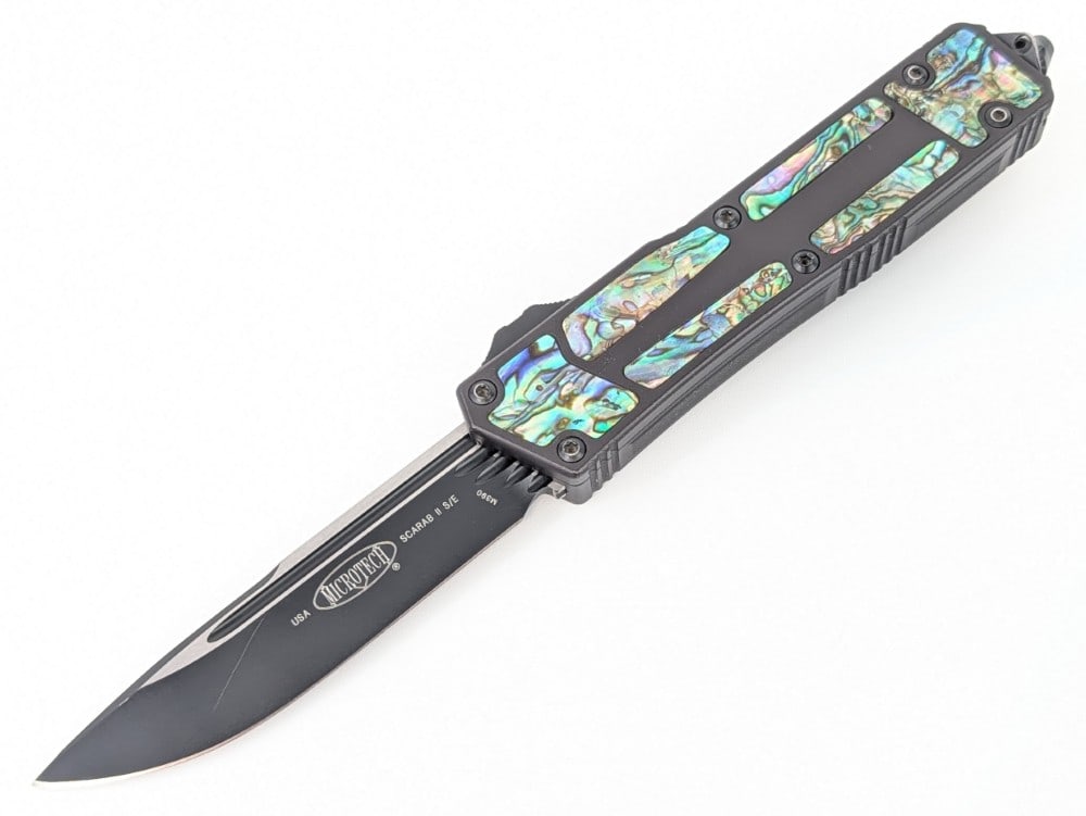 2021 Microtech Scarab II Abalone OTF Knife: Knife is dated 03/2021 S/N 1576 and features custom abalone inserts, and a glass breaker pommel. The abalone inserts are very flush with the edge of the handle, and the knife weighs 5.84oz.