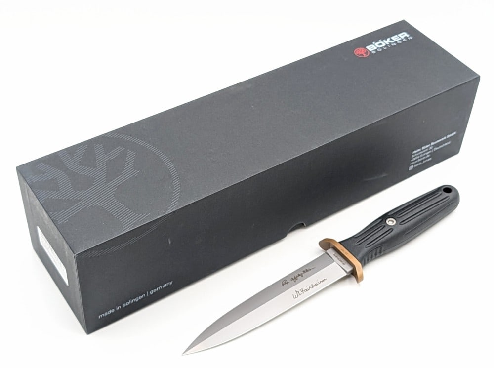 NIB Boker Plus Applegate-Fairbairn Combat II w/ Sheath: Features a bead blast finish blade, a brass double guard, and a reinforced delrin handle. Knife is in new condition. Blade length measures 6in and overall 10-3/4in.