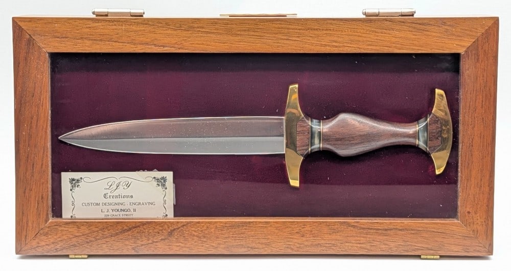 L.J. Youngo II Custom Presentation Dagger w/ Case: Features a double edged blade, a polished brass double guard, a shaped wood handle with horn spacers, and a polished brass pommel. Knife closely resembles the WWII German dress dagger. Knife is in ver