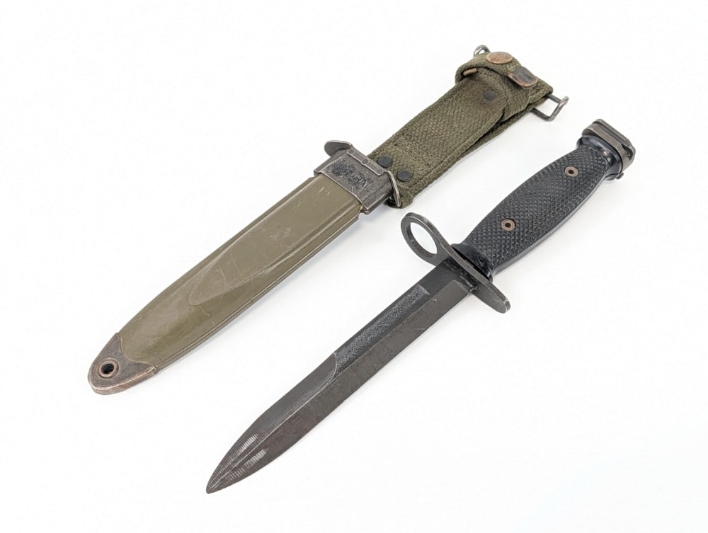 Vietnam Era U.S. Bauer M7 Bayonet w/ Scabbard: Bayonet is in nice condition with light scratches and finish wear on the blade, and other scuffs from use and handling. Blade length measures 6-5/8in and overall 11-3/4in.