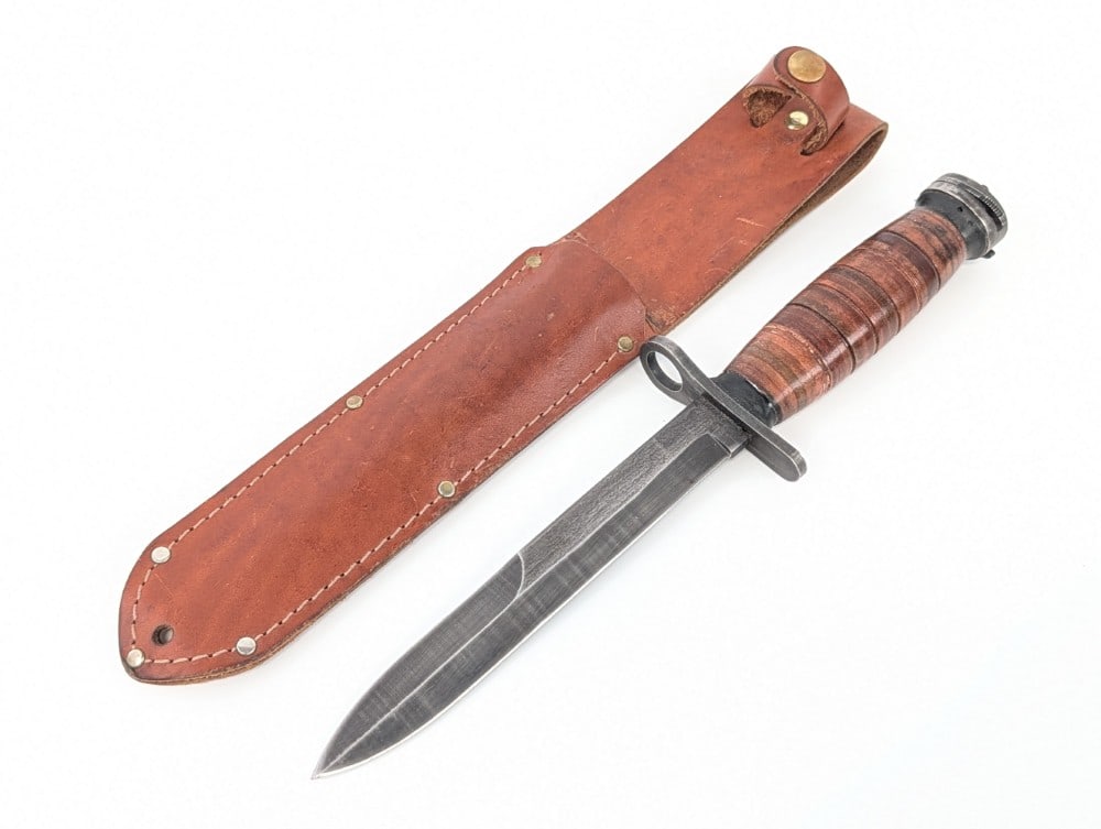 Stacked Leather M7 Bayonet w/ Sheath: Knife is unmarked, but the sheath is marked Ontario USA. Knife is in nice condition with light scuffs and finish wear and the blade, and other scattered scuffs. Blade length measures 6-5/8in and overa