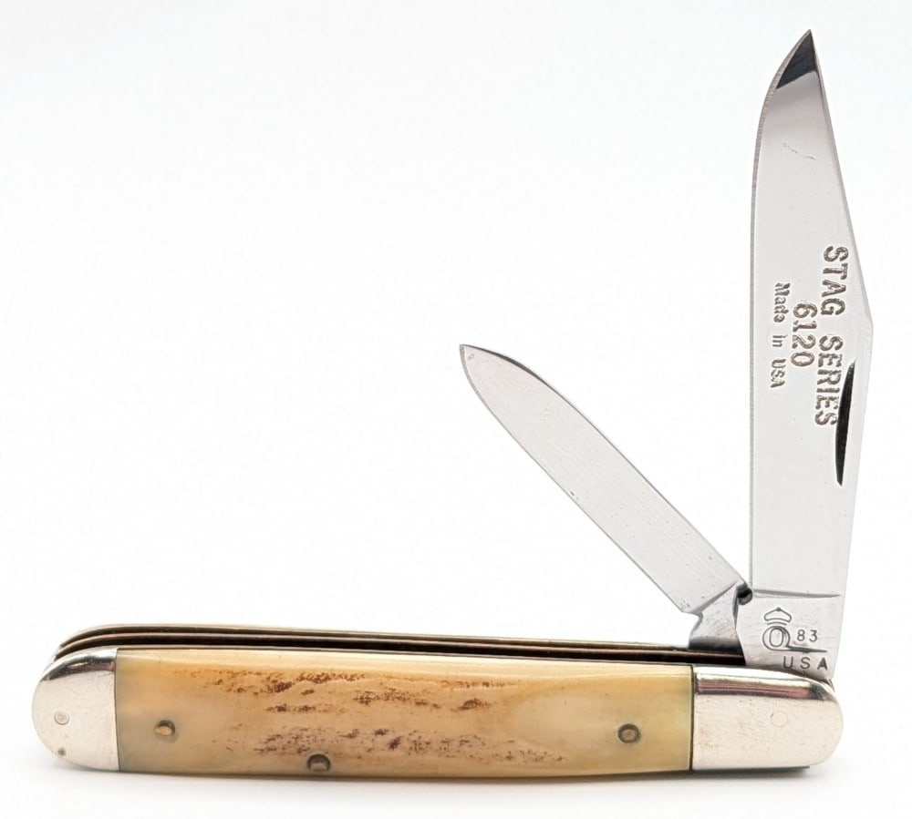 1983 Queen Cutlery Co. Stag Series Jack Knife 6120: Knife is in good condition with light scuffs on the blades, and scratches and tarnishing on the bolsters from handling and age. Overall measures 4-1/2in when closed.