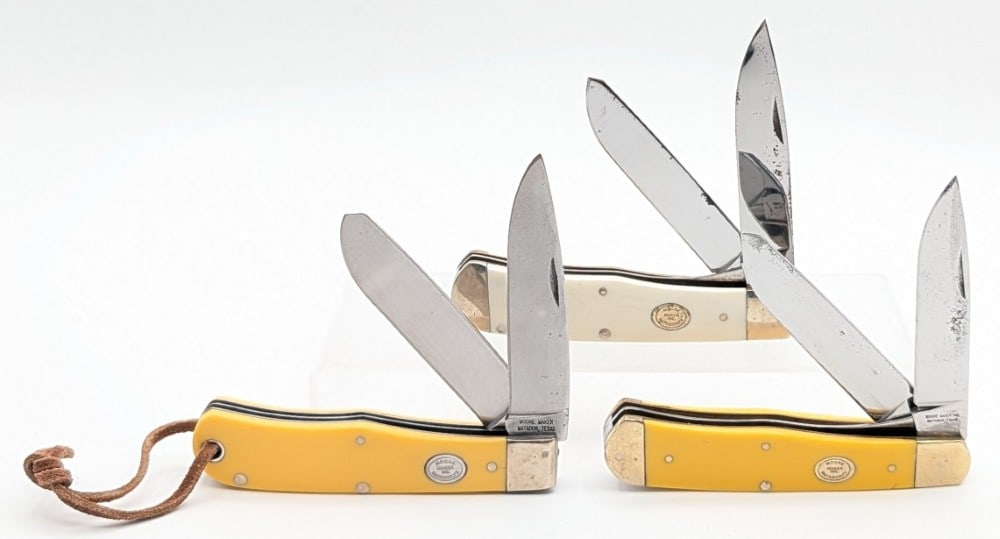 (3) Moore Maker Inc. Synth Yellow & White Large Trappers: Knives are in fair condition with some rusting on the blades, scratches and tarnishing on the bolsters, and some small pin cracks. Overall measures 4-1/2in when closed.