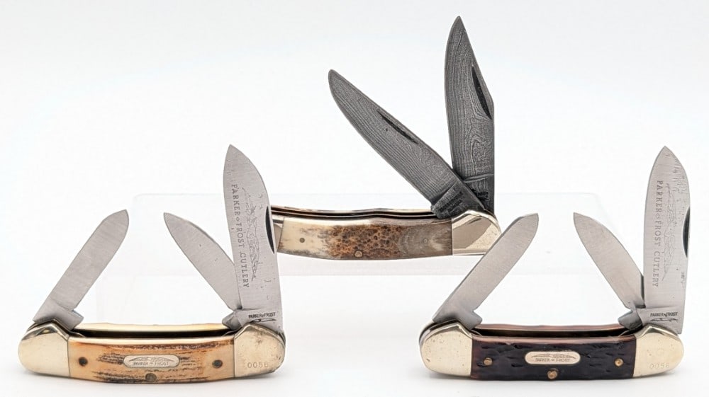 (3) Parker Frost Bone & Stag Handle Folding Knives: Includes two canoe style knives, and a damascus folding hunter. Knives are in good condition with light scuffs and tarnishing on the bolsters from handling. Overall measures 3-3/4in when closed.