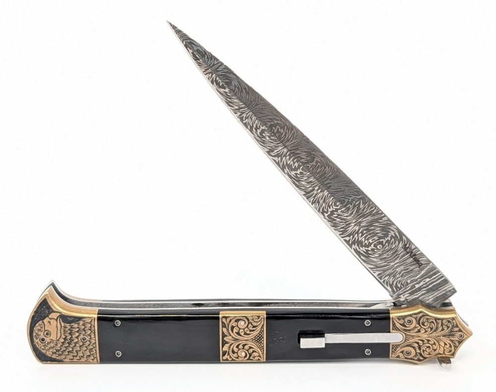 M. Afaaq Custom Knives 11in Mosaic Damascus Buffalo Horn Switchblade Knife: Features a mosaic damascus blade, file work along the spring, engraved brass bolsters with a beak pommel, and buffalo horn inserts. Knife is in like new condition. Overall measures 6in when closed.