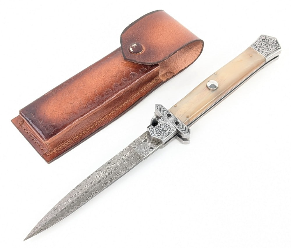 Custom 13in Damascus Horn Handle Switchblade Knife w/ Sheath: Features a damascus blade, an engraved cross guard, and an engraved bolster. Knife is in like new condition.