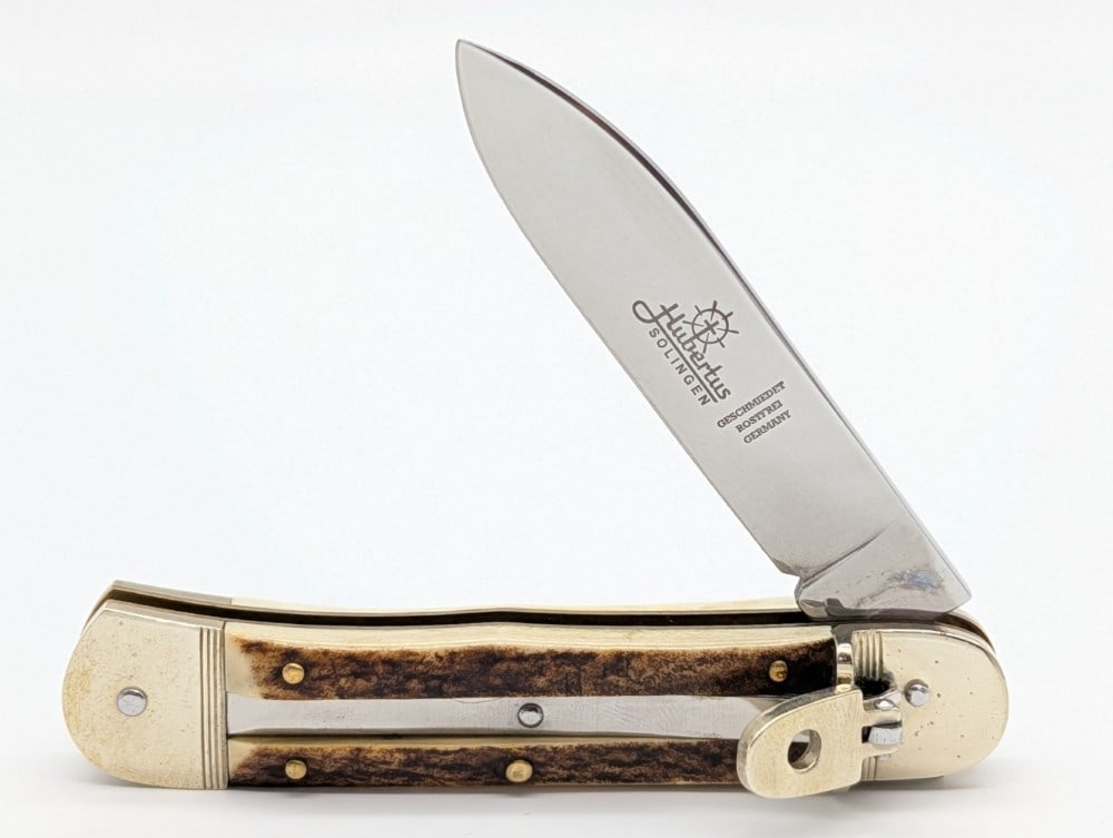Hubertus Solingen Stag Leverlock Switchblade Knife: Knife is in very nice condition with light scuffs and tarnishing on the bolsters from handling. Overall measures 4-1/2in when closed.