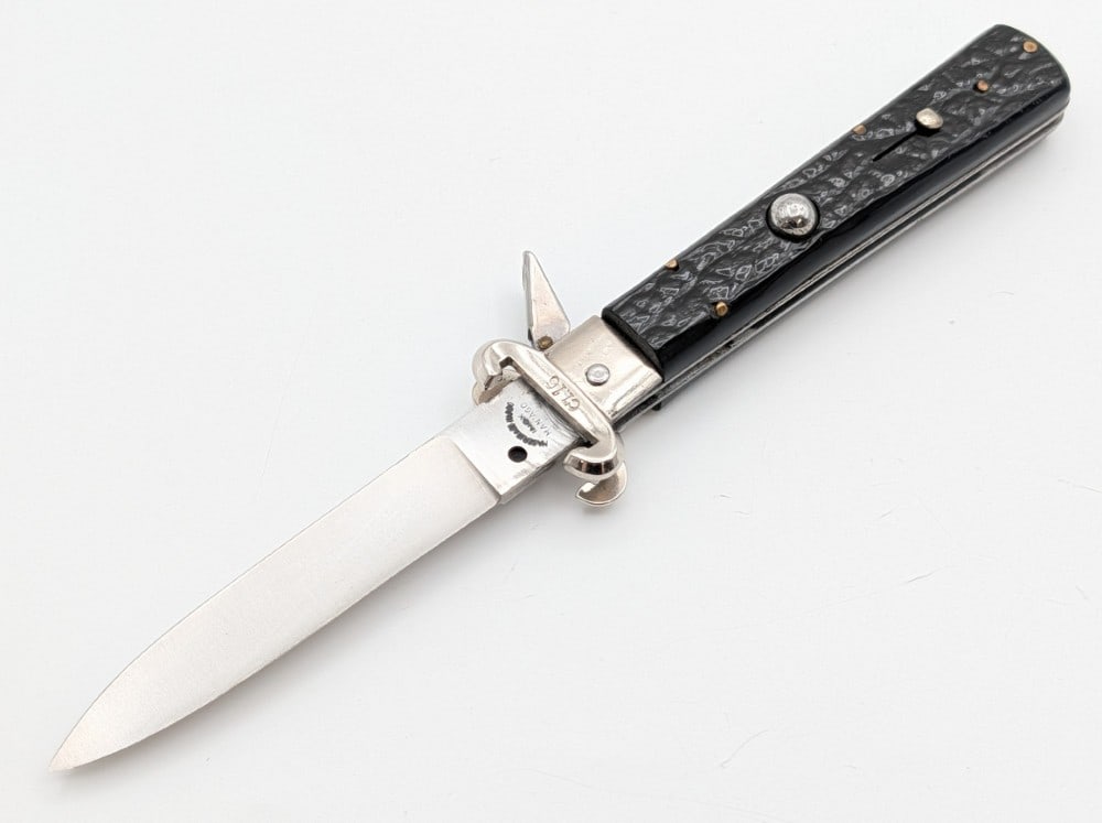 Maserin & DeNardo Rough Black Shell Puller Switchblade Knife: Knife is in nice condition with some dings and tarnishing on the bolster. Spring is nice and strong, and locks tight when open. Overall measures 4-3/4in when closed.