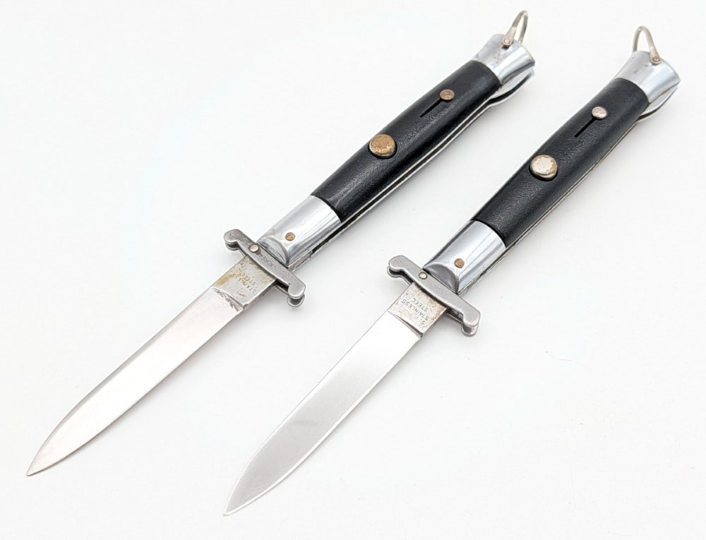 Unmarked Synth Black Swing Guard Switchblade Knives: Knives are in good condition with light scratches on the blades, scuffs on the bolsters, and scuffs on the handle scales. Both blade springs work and lock tight when open. Overall measures 4-3/4in