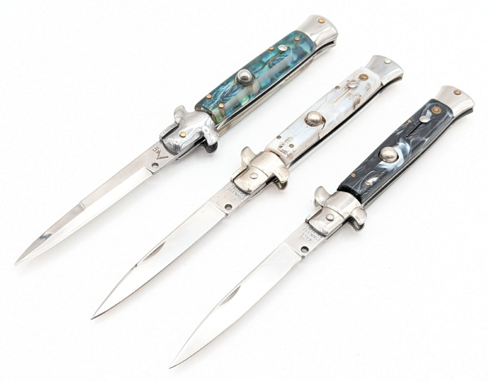 Rostfrei AKC 9in Stiletto Switchblade Knives: Knives are in good condition with some tarnishing on the blades, scuffs on the bolsters, and the faux pearl handle has a bad crack. Overall measures 5in when closed.