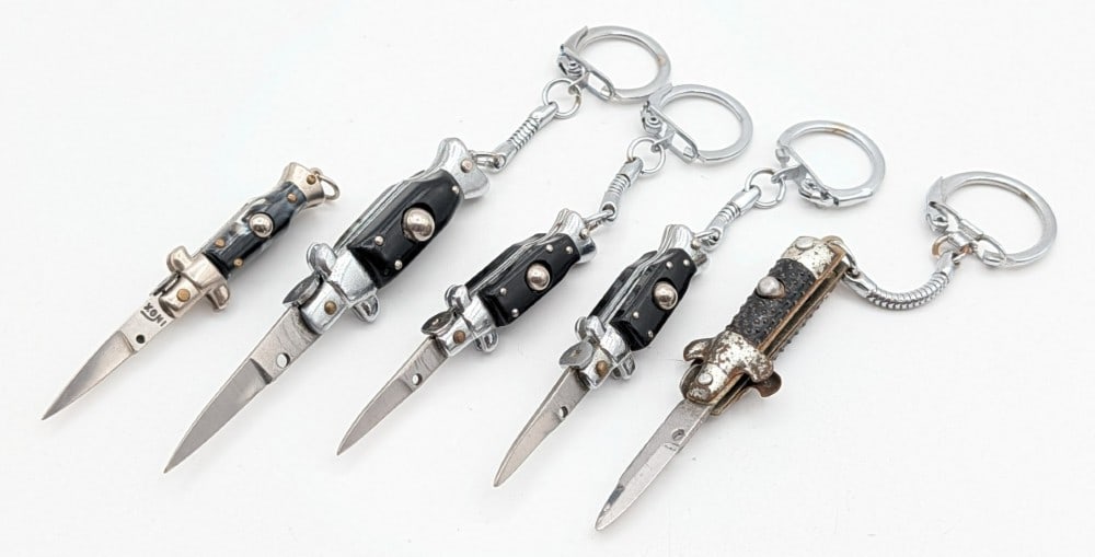 (5) Mini Keychain Switchblade Knives: Knives are in aged condition with different amounts of scratches and tarnishing from handling and age. Largest overall measures 2in when closed.