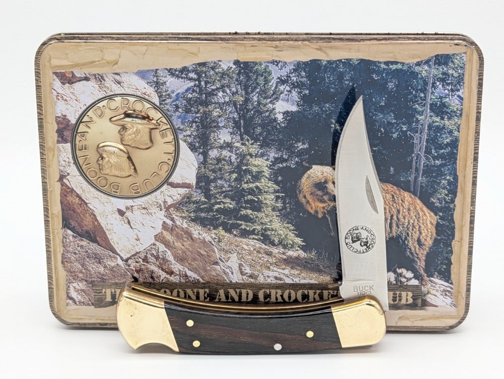 Buck 110 Boone & Crockett Club Smooth Wood Lock Back Knife w/ Tin: Knife is in very nice condition with light tarnishing on the bolsters from age. The plastic insert is badly cracked. Overall measures 4-3/4in when closed.
