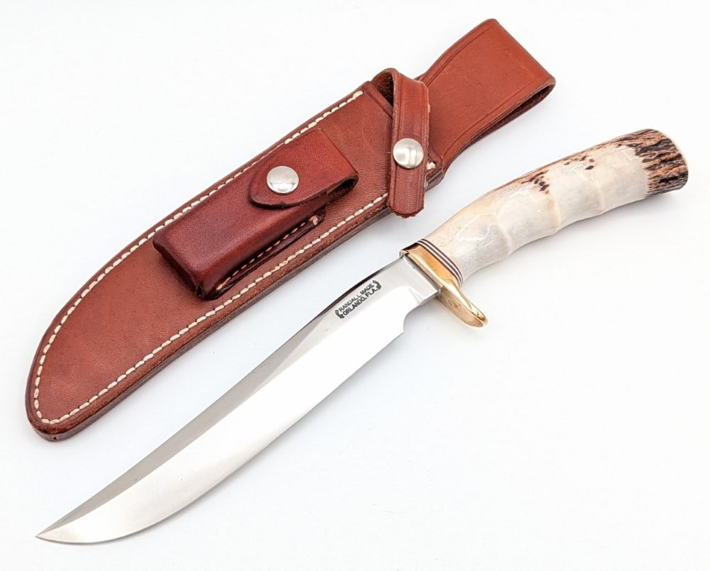 1980's Randall Model 3 7in Finger Groove Stag Hunter w/ Sheath: Features a brass single downturned guard, and a finger groove stag handle. Knife is in very nice condition with light tarnishing on the blade and guard from age. Blade length measures 7in and overall 