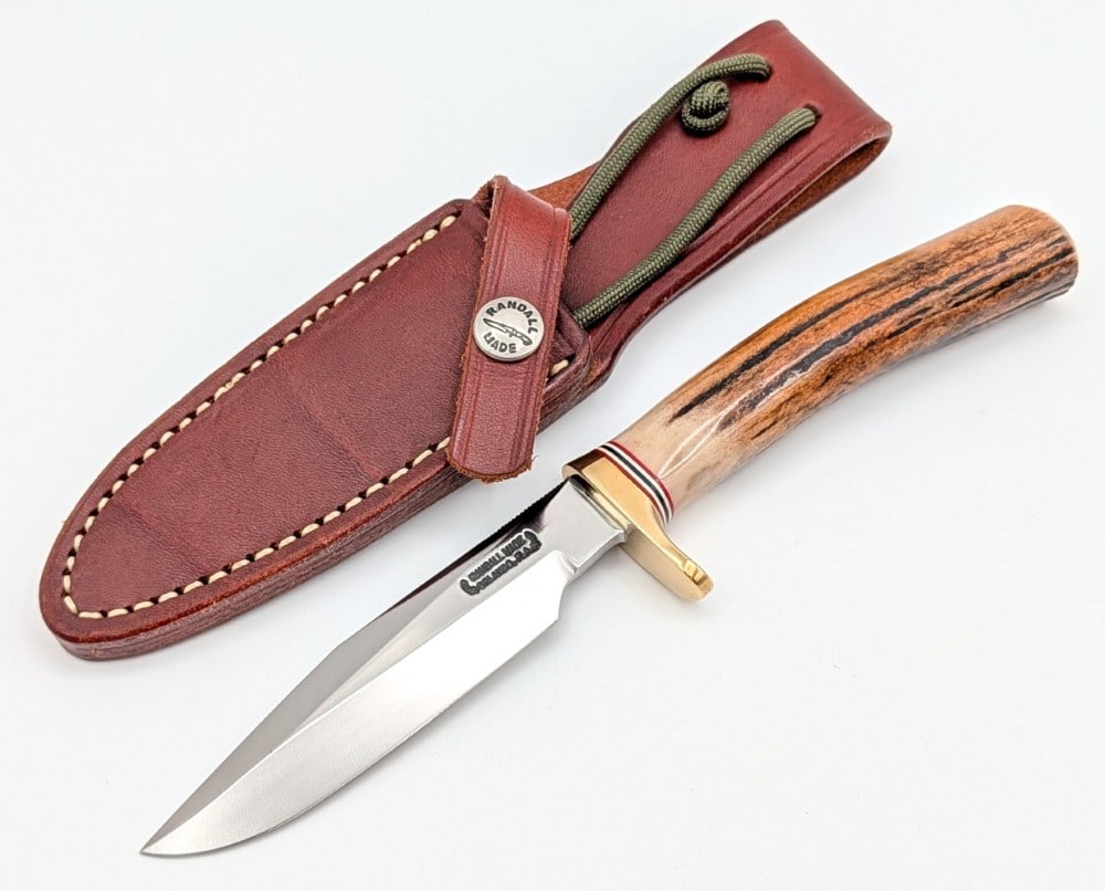 Randall Model 5 4in Camp & Trail Knife w/ Sheath: Features thumb notches on the blade, a brass single downturned guard, and a stag handle. Knife is in very nice condition with light scuffs from handling. Blade length measures 4in and overall 8-3/8in.