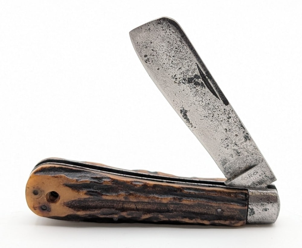 Russell & Co. Green River Works Stag Razor Knife: Knife is in aged condition with heavy scratches and pits on the blade, pits and scratches on the bolsters, and cracks on both the front and back handle scale bottom pins. Overall measures 4-1/4in when
