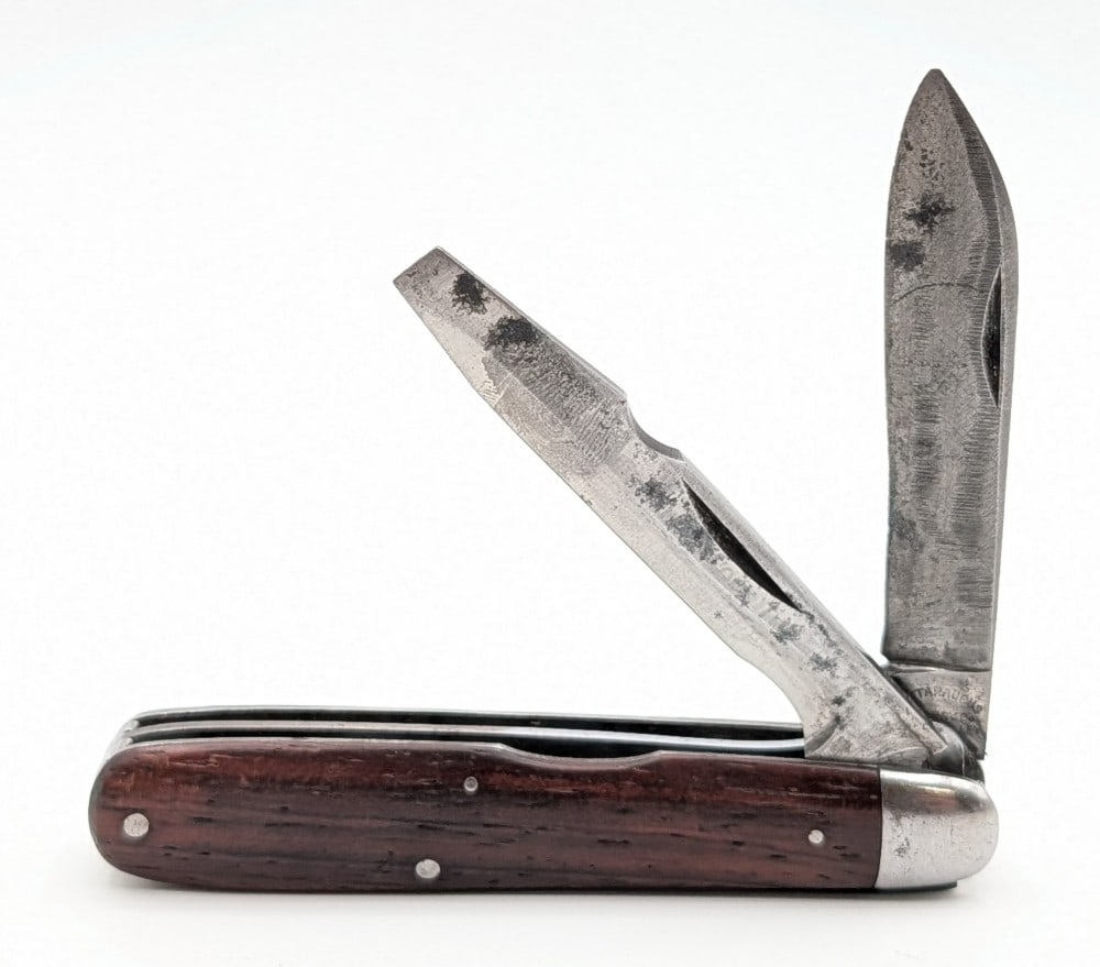 Cattaraugus Smooth Wood Bare Headed Jack Knife: Knife is in fair aged condition with heavy scratches and material loss on the blades, and scuffs and tarnishing on the bolsters. Overall measures 3-5/8in when closed.