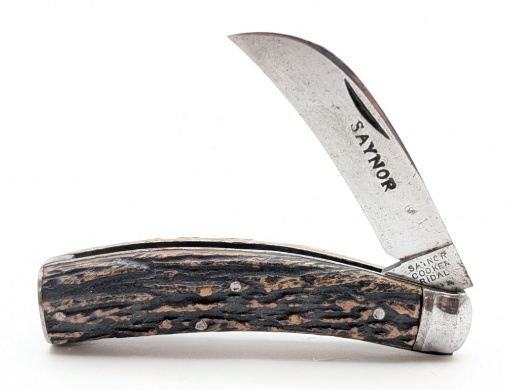 Saynor Cooke & Ridal Stag Hawkbill Knife: Knife is in nice aged condition with light scratches and carbon spots on the blade, light tarnishing on the bolsters and butt cap, and nice handle scales. Overall measures 4in when closed.