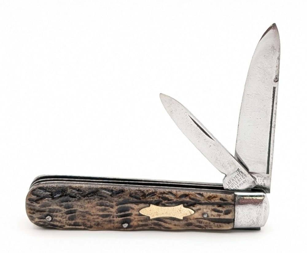 Lafayette Cutlery Co. Stag Long Pull Bare Headed Jack Knife: Knife is in fair cleaned condition with heavy scratches and material loss on the polished blades, scratches and dings on the polished bolsters, and an interesting long single groove on the back handle