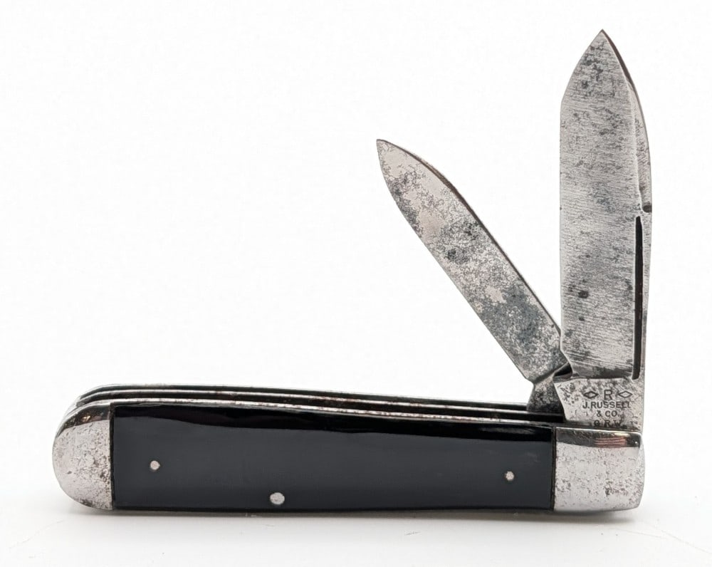 J. Russell & Co. Slick Black Uneven Jack Knife: Knife is in fair cleaned condition with scratches and tarnishing on the blades, tarnishing on the polished bolsters, and general scuffs on the handle scales. Overall measures 3-3/4in when closed.