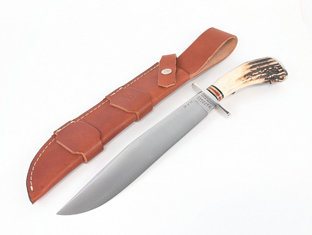 2001 Marble's Custom Crown Stag Bowie Knife w/ Sheath: Knife is numbered 06 of 5o. Features a satin finish blade, a polished steel double guard, a stag handle, and a polished steel butt plate. Knife is in like new condition. Blade length measures 9-5/8in 
