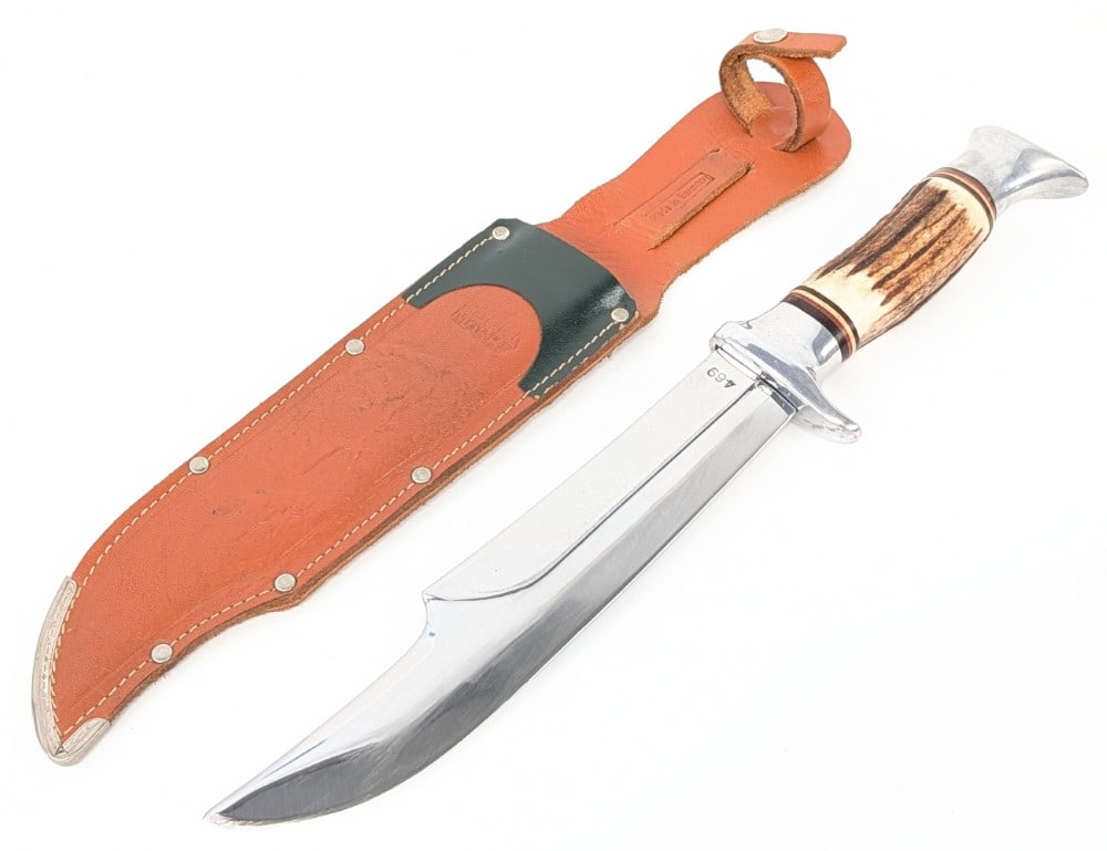 Edgemark 469 Stag Bowie Knife w/ Sheath: Features a large mirror finish clip point blade, an aluminum single guard, a stag handle, and an aluminum butt cap. Knife is in used condition with scratches on the blade, and other scuffs and wear fr