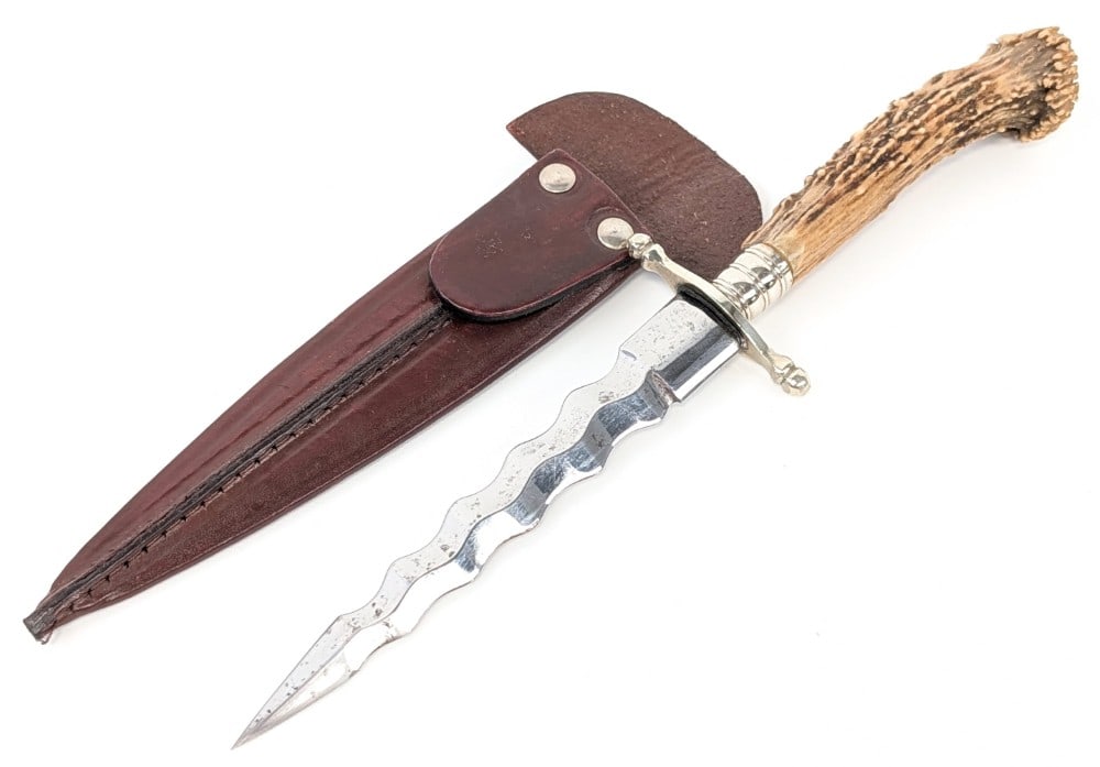 Crown Stag Criss Boot Dagger w/ Sheath: Features a kriss blade, a nickel silver double guard, a nickel silver collar, and a crown stag handle with a nickel silver butt cap. Knife is in very nice condition with carbon spots on the blade. Bla