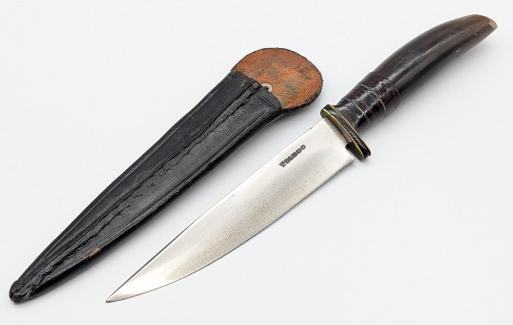 Spanish Toledo Horn Handle Boot Knife w/ Sheath: Features a straight back blade, a brass guard with a leather spacer, and a horn handle. Knife is in good condition with some scuffs and tarnishing on the blade from age. Blade length measures 5-3/8in 
