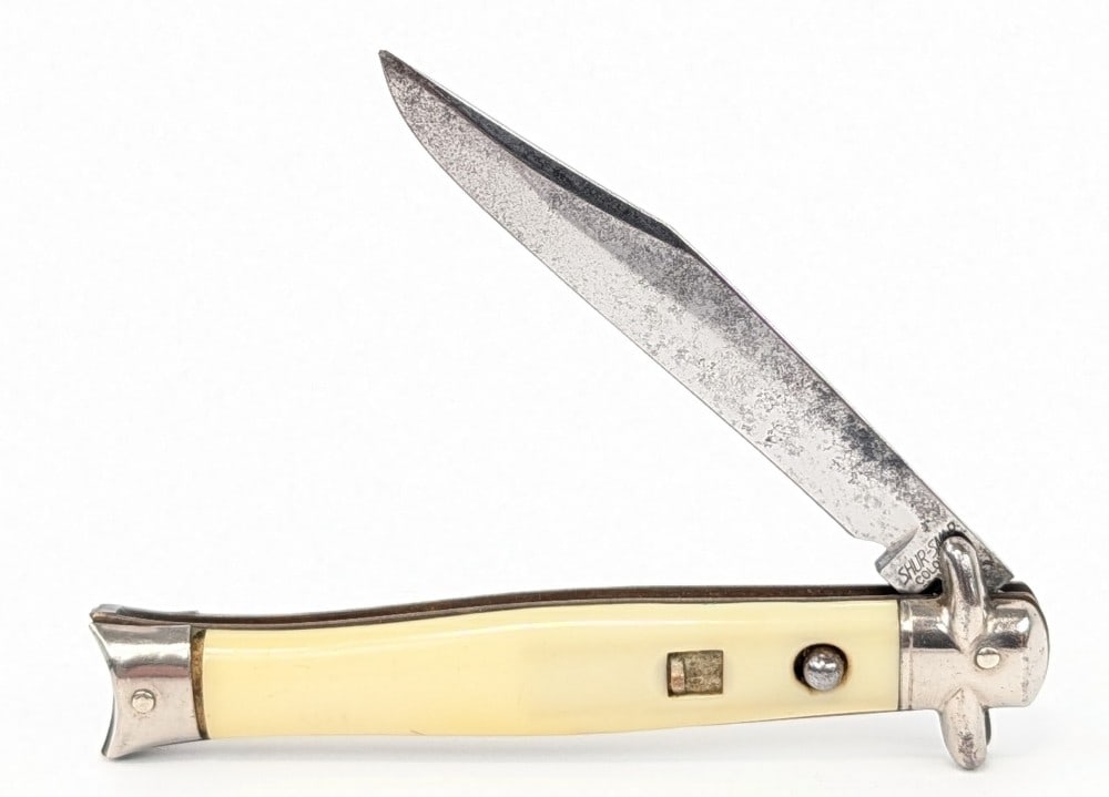 Shur-Snap Colonial Synth White Bowtie Fishtail Switchblade Knife: Knife is in fair aged condition with carbon spots and some pits on the blade, scuffs on the bolsters, and yellowing on the handle scales. Spring is nice and strong, but the blade does not stay locked 