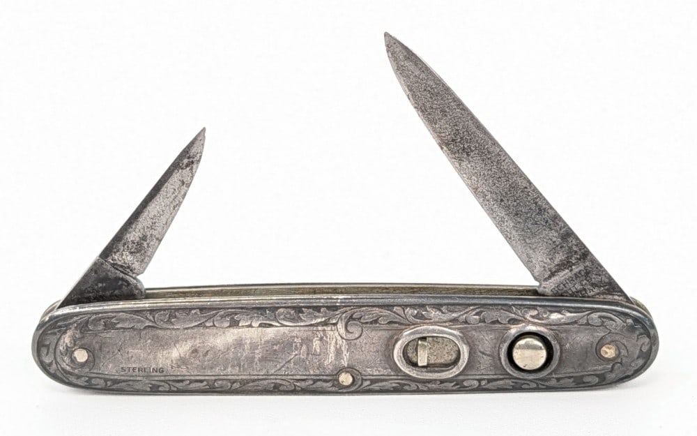 Schrade Cut Co. Sterling Silver Double Switchblade Knife: Knife is in aged condition with heavy material loss and scratches on the blades, and scratches and tarnishing on the handle. The main blade spring is weak and does not lock open, and the secondary bla