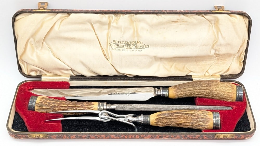 IXL George Wostenholm Stag Carving Knife Set w/ Case: Features mirror polished blade and fork, silver plated collars and butt caps, and stag handles. Pieces are in good condition with a fair amount of scratches on the carving blade from use and handling.