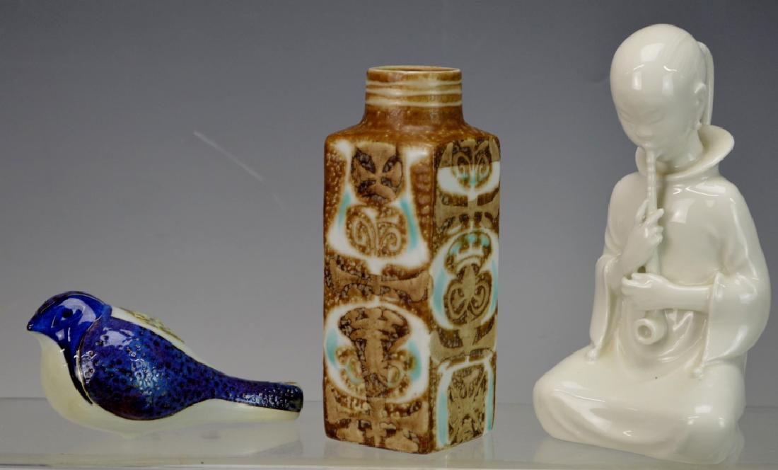 Royal Copenhagen Porcelain Grouping: Includes Royal Copenhagen (1) White Porcelain Figurine smoking pipe. Designed by: Arno Malinowski Model No. 2342, (1) Nils Thorsson Royal Copenhagen Baca Small Vase (1) porcelain bird whistle. Largest