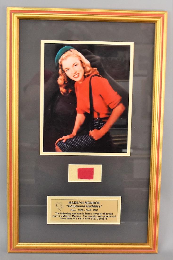 Marilyn Monroe Sweater Piece: Included is a rare piece of Marilyn Monroe's iconic red sweater. It comes with COA description and provenance as well as a photo of Marilyn Monroe and plaque in a beautiful frame. measures: 21.75" x 1