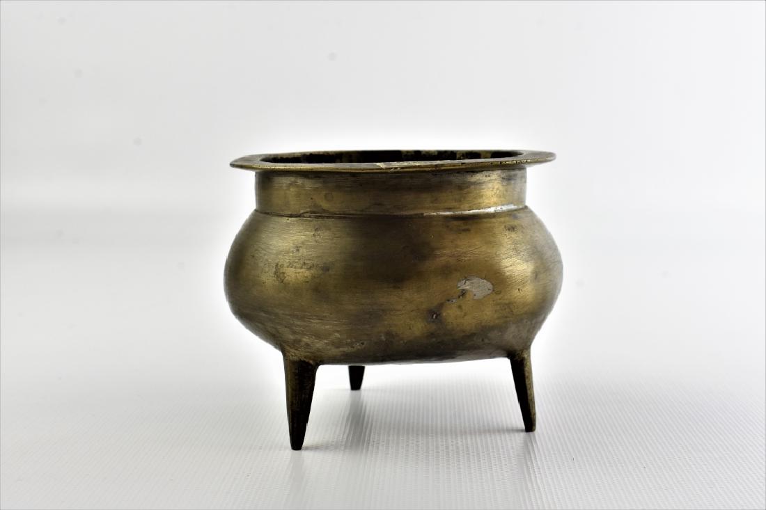 Antique Chinese Bronze Censer: A Chinese Bronze Censer. A deep basin resting on three tapered legs, with trace remains of a Jianding. it is marked with character on its base. It retains its original finish.