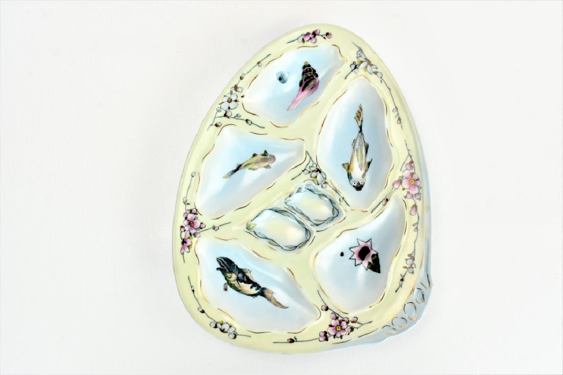 Hand Painted Limoges Oyster Plate: A Hand Painted Limoges Oyster Plate with 5 wells and sauce holders. Painted with shells, fish, and floral designs, with the gold Limoges name and crown with two crossed swords insignia on the back. Me