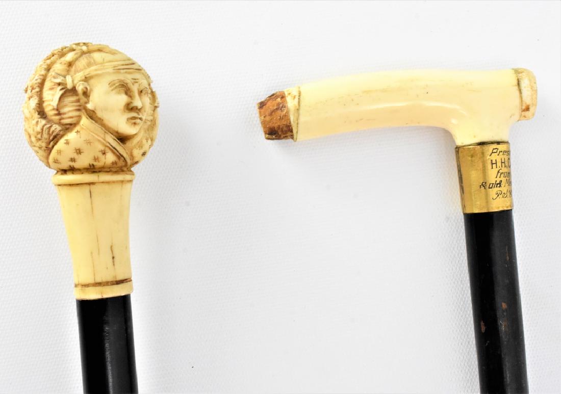 Carved Presentation Walking Sticks: Carved Presentation Walking Sticks (2) One missing brass mount, was presented to H. H. Cambes Esq. From Committee & old Members of P & G Southend 1921, measures 36in, and the other is a carved Japanes