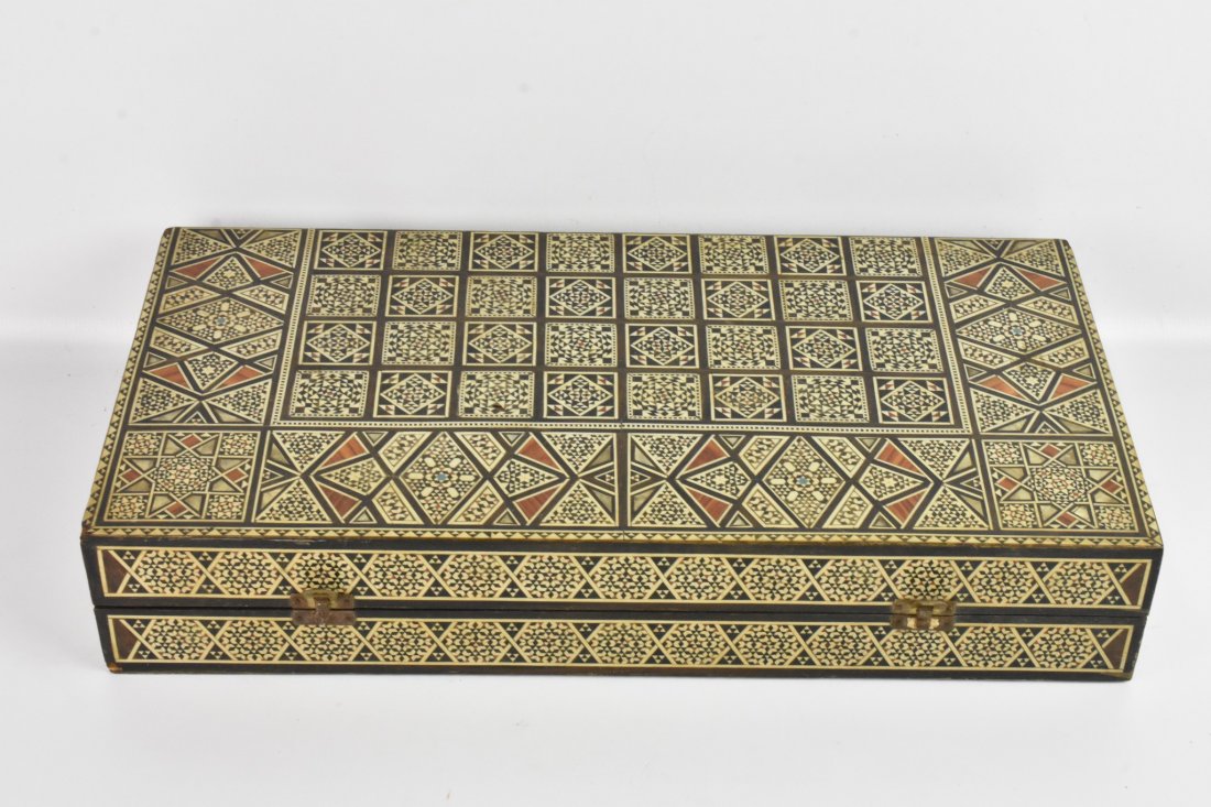 Backgammon Set: A Backgammon Set that includes a wooden case with an octagonal cup, wood chips, and wood dice. Case, chips, and cup are inlaid with various designs.