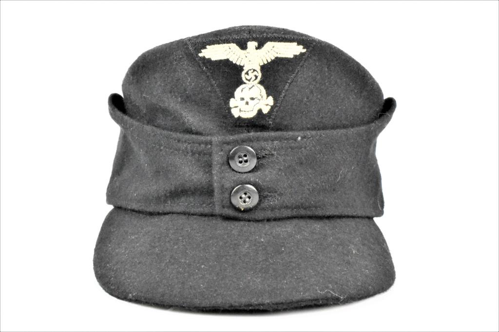 Waffen SS M-43 Cap: Scarce Waffen-SS M43 cap, coarse black wool with two bakelite button flap, with trapazoidal wool eagle and totenkopf patch sewn to front of cap at the time of manufacture. The sides and top of the int