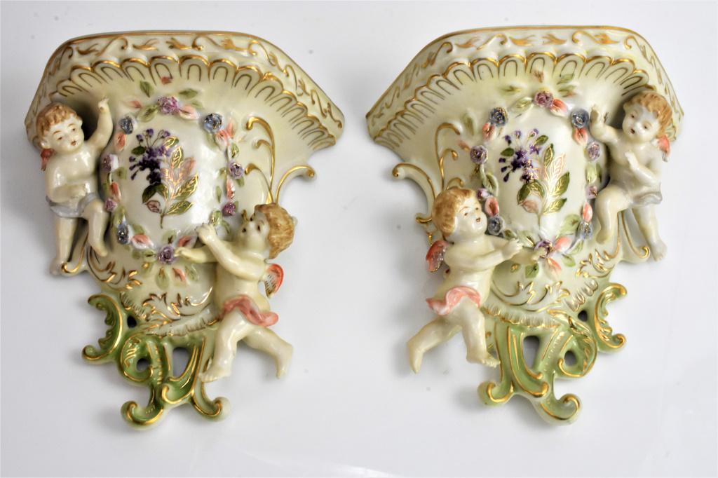 German Porcelain Style Wall Brackets: Each shelf measures appros 8 inches tall and 8 inches wide. Floral decorated putti or angels.
