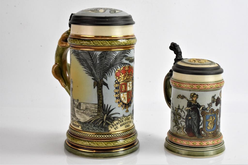 Pair of Villeroy & Boch Mettlach grouping: Larger stein measures 8" high and is missing the dragon head, has the Spanish code of arms St. Augusting Florida 1565. On the bottom has the Mettlach marking are faded and stamps are still visible. nu