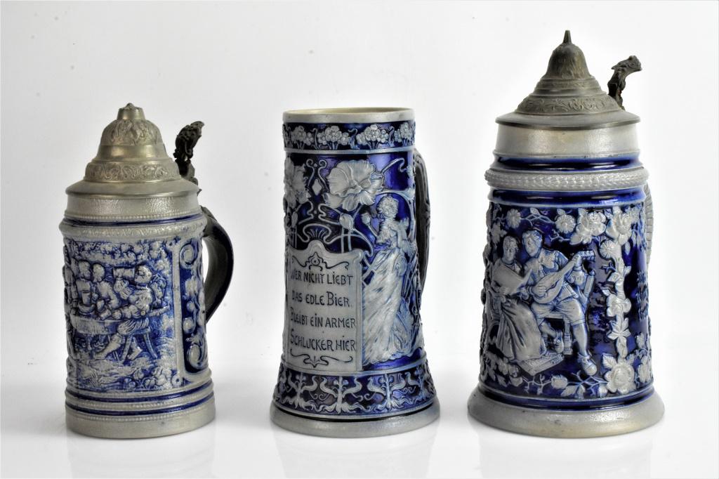German Beer Stein Grouping: Grouping includes (3) German beer steins, tallest measuring approx. 9.75"h. (2) of the (3) steins are lidded. Stein that is not lidded is hallmarked, but has two hairlines. All are marked Germany or o